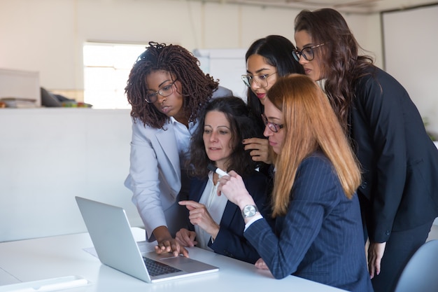 Businesswomen discussing project at laptop computer