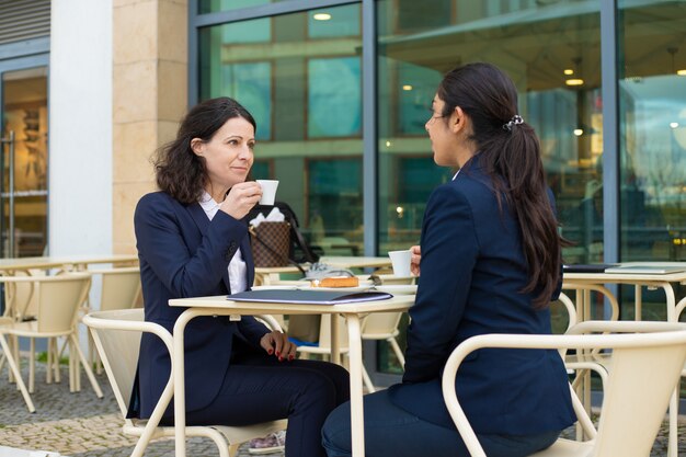 Businesswomen drinking coffee in outdoor cafe