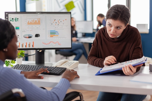 Businesswomen planning financial strategy looking on computer working together in start up company officet