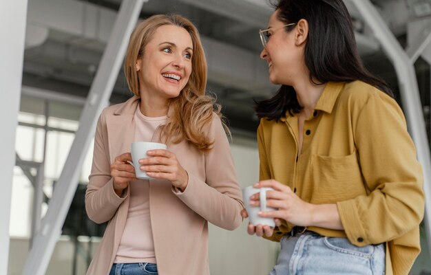 Businesswomen talking while enjoying a cup of coffee