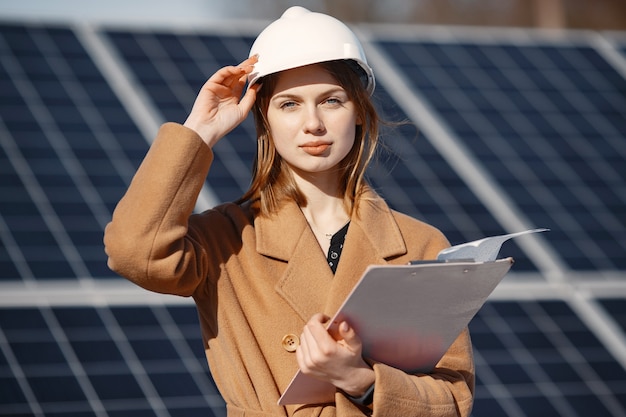 Foto gratuita imprenditrici che lavorano sul controllo delle apparecchiature presso la centrale solare. con elenco di controllo tablet, donna che lavora all'aperto a energia solare.