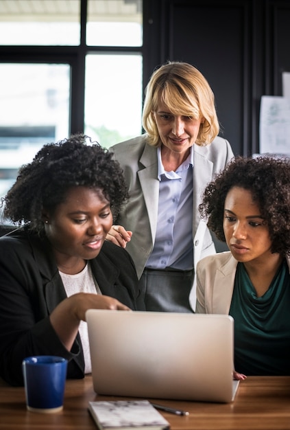 Free photo businesswomen working on a laptop