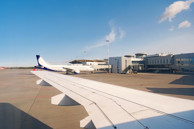 Оживленный вид на аэропорт с самолетами на фоне ясного неба