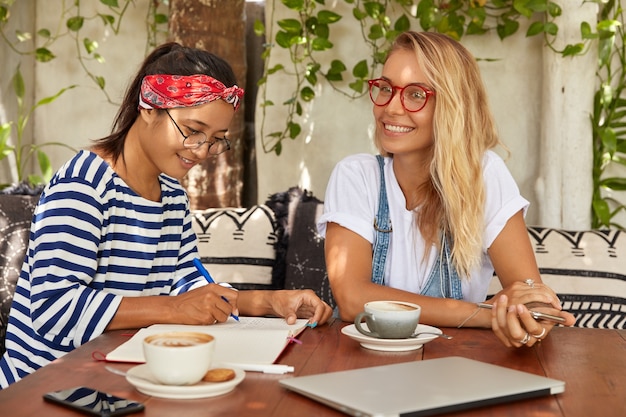 Free photo busy asian journalist takes interview in famous celebrity, makes notes in notepad