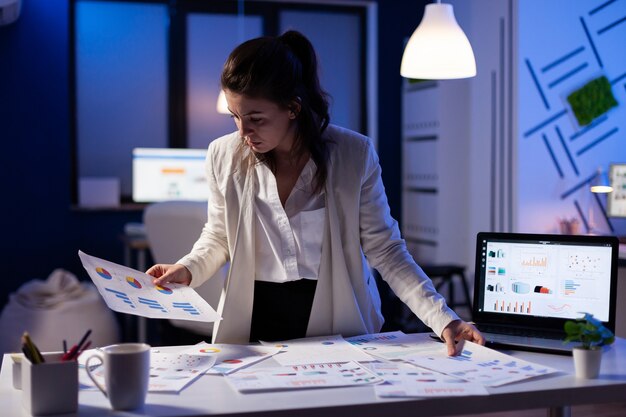 Busy business woman working on financial reports checking numbers for executive meeting