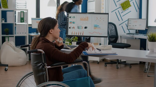 Busy disabled woman talking at phone with business partner