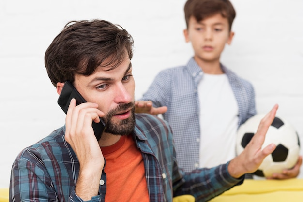 Busy young father talking on phone