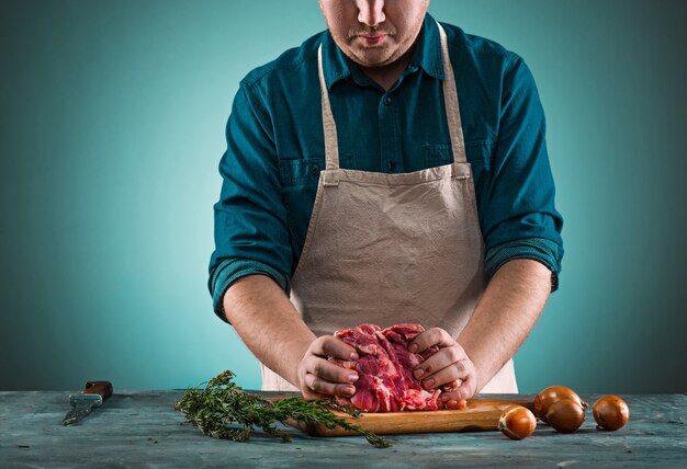 Butcher cutting pork meat on kitchen