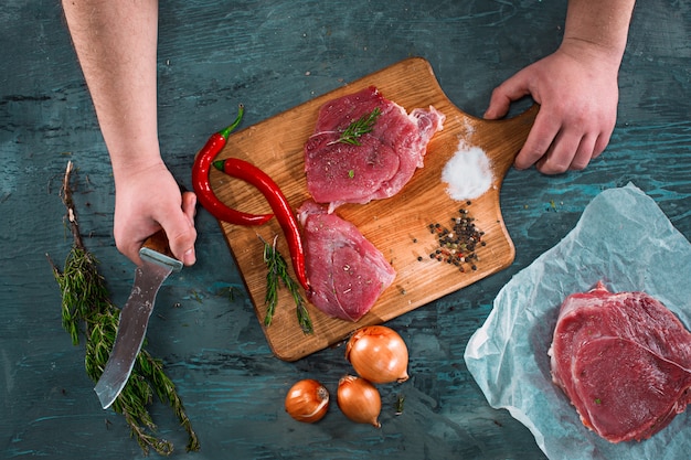 Free photo butcher cutting pork meat on kitchen