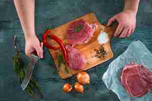 Free photo butcher cutting pork meat on kitchen