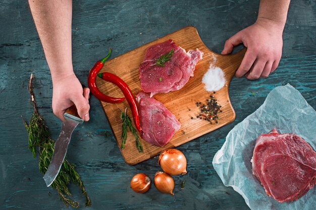 Butcher cutting pork meat on kitchen