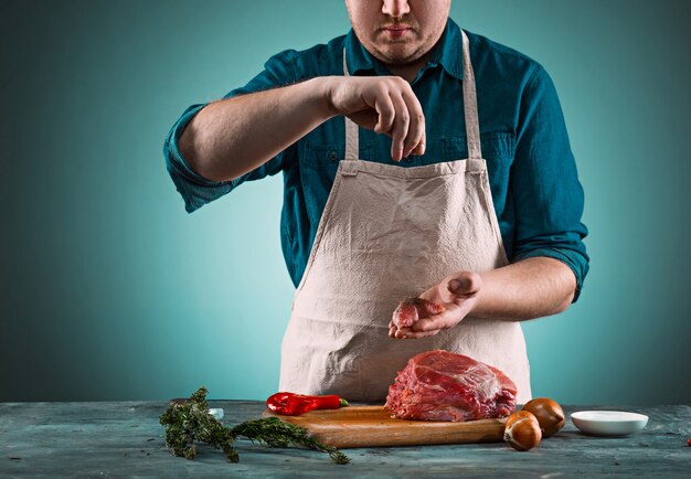 Butcher cutting pork meat on kitchen