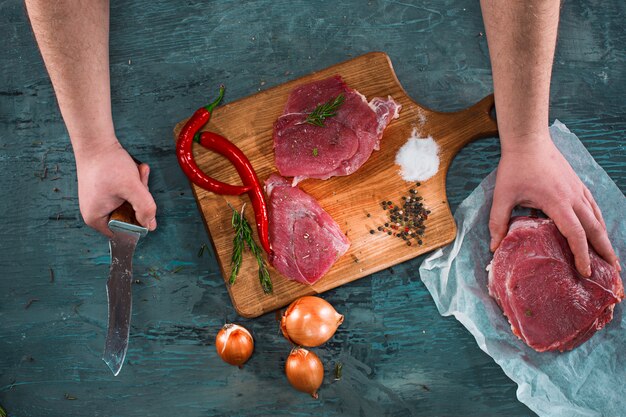 Butcher cutting pork meat on kitchen