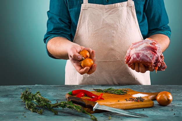 Macellaio con carne di maiale in cucina