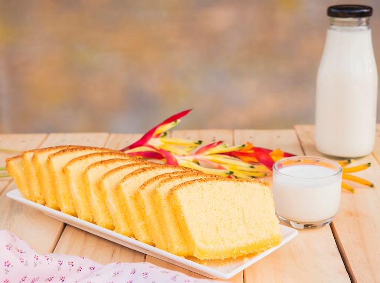 Free Photo butter cake and bottle with glass of milk on white wooden table