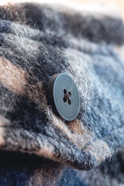 Button on a warm blue shirt macro shot