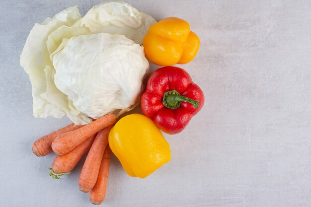 Cabbage, carrots and bell peppers on stone table. High quality photo