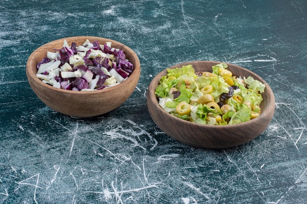 Cabbage and lettuce salads in wooden cups. 