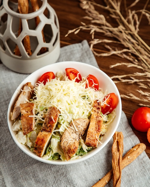 Vista laterale delle acciughe del pomodoro del formaggio della lattuga del pollo di caesar