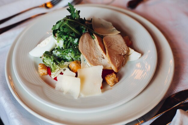 Caesar salad on a white plate looks nice and tasty brightLooking tasty White table