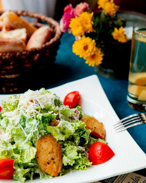 Caesar salad with chicken served with bread