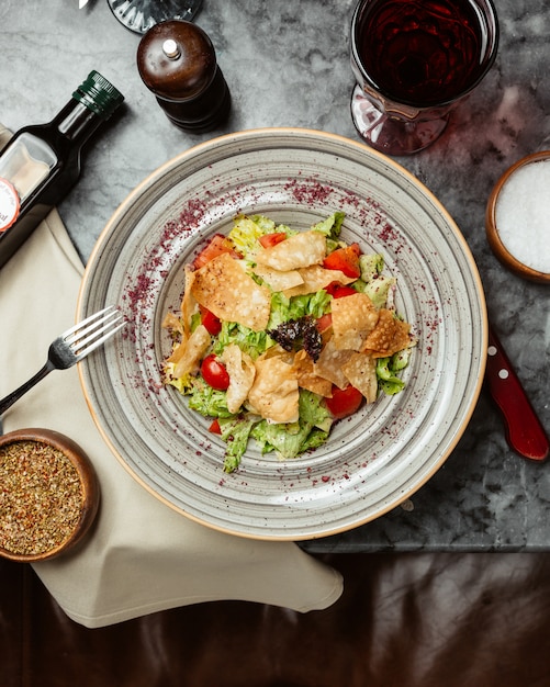 Caesar salad with crackers and tomatoes.