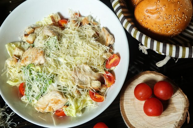 Caesar salad with fried chicken and side bread