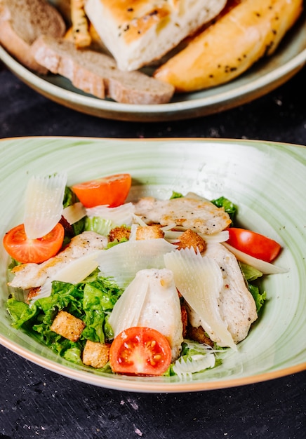 Free photo caesar salad with greenery,tomatoes and chopped parmesan.