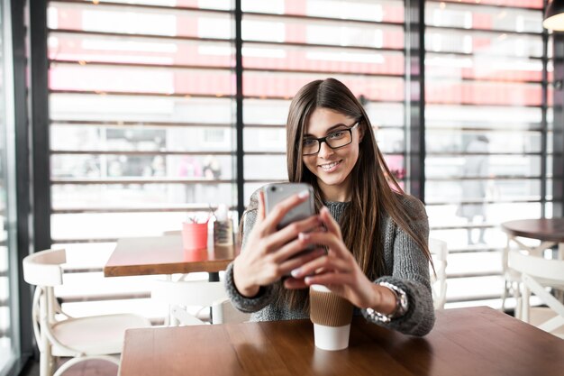 カフェモバイル女性のコーヒーを使用して