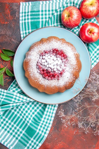 a cake a cake with berries apples on the white-blue tablecloth