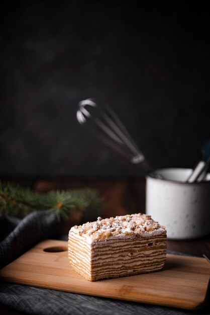 Cake on chopping board with kitchen utensils