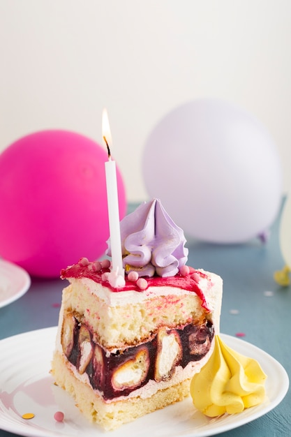 Free photo cake piece with candle and balloons