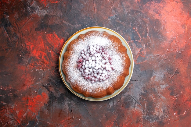 Un piatto da torta di una torta appetitosa con ribes rosso e zucchero a velo