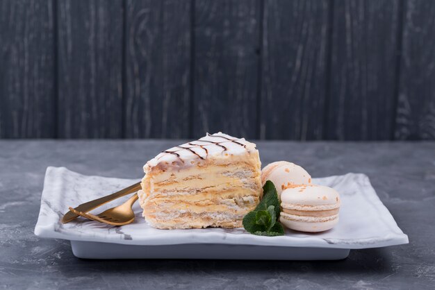 Cake on plate with cutlery and macarons