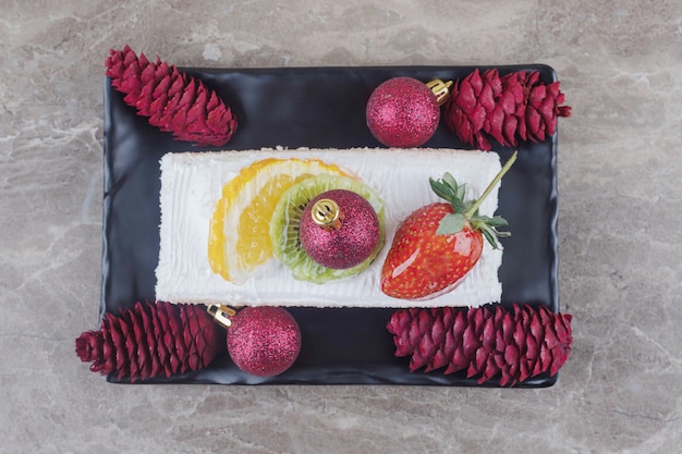 Cake slice on a platter adorned with festive decorations on marble 