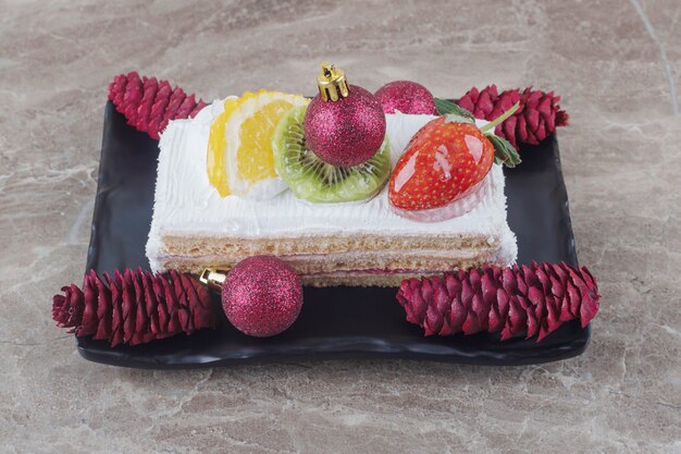 Cake slice on a platter adorned with festive decorations on marble 