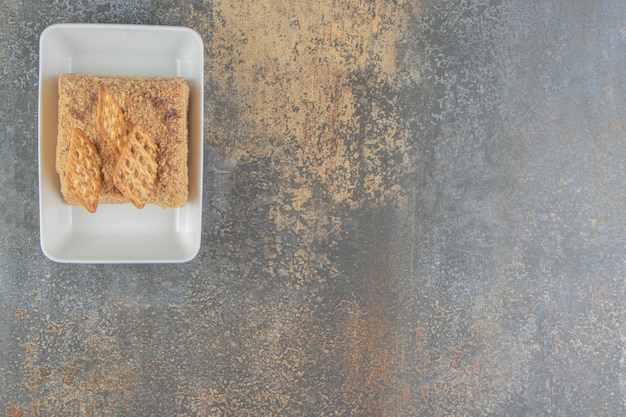 Free photo cake slice with crackers in a platter