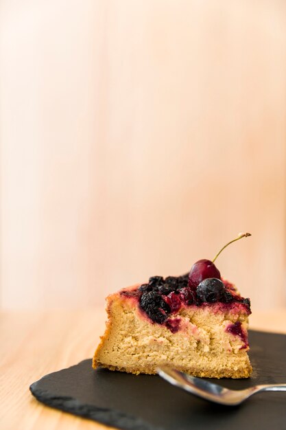 Cake slice with spoon on shale board