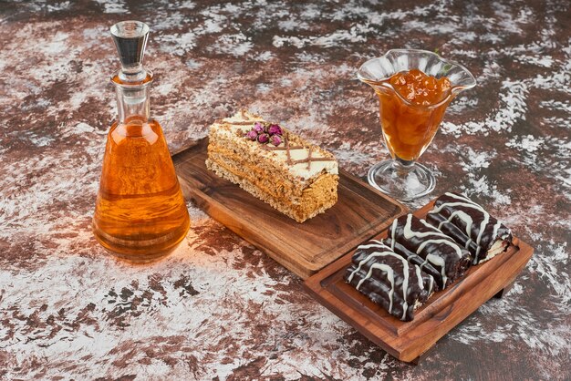 Cake slices and confiture on a wooden board.