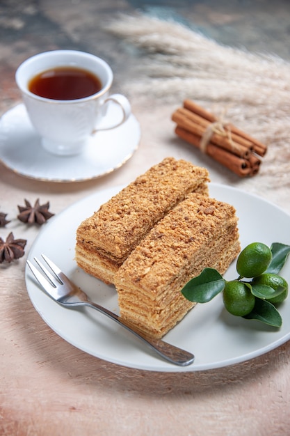 cake slices honey cake with cup of tea on grey