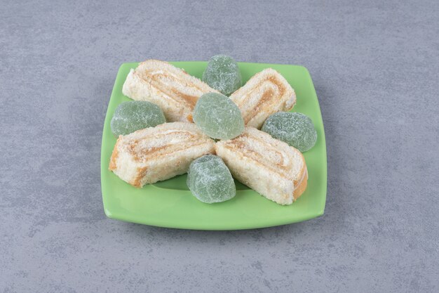 Foto gratuita fette di torta e marmellate su un vassoio verde su marmo `