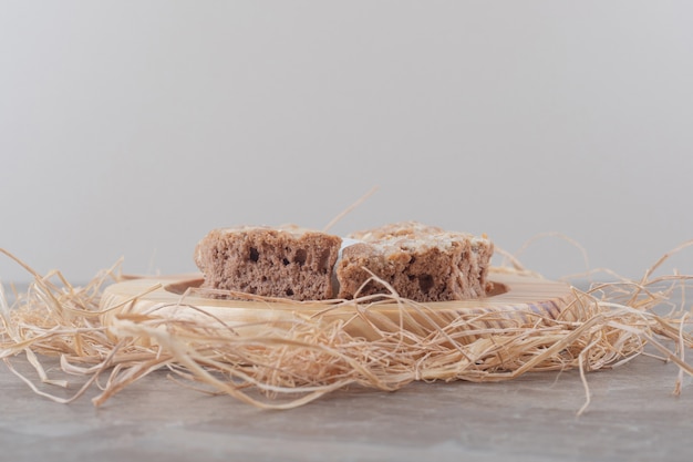 Free photo cake slices on a wooden plate on marble