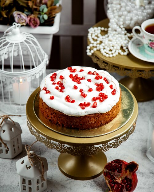 Cake with cream and pomegranate on top