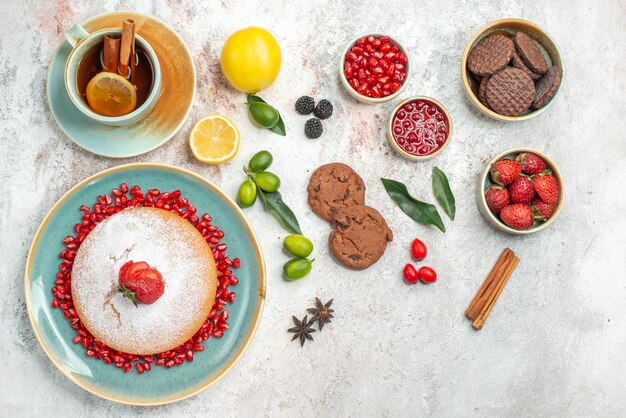 차 한잔과 함께 케이크 계피 스틱을 곁들인 홍차 한잔 테이블에 딸기 스타 아니스 초콜릿 쿠키 케이크