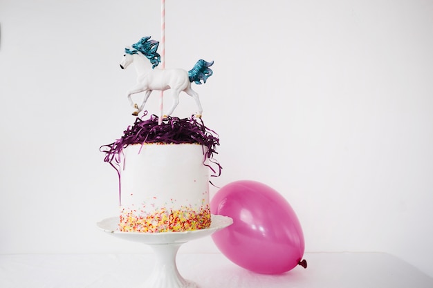 Cake with horse near balloon