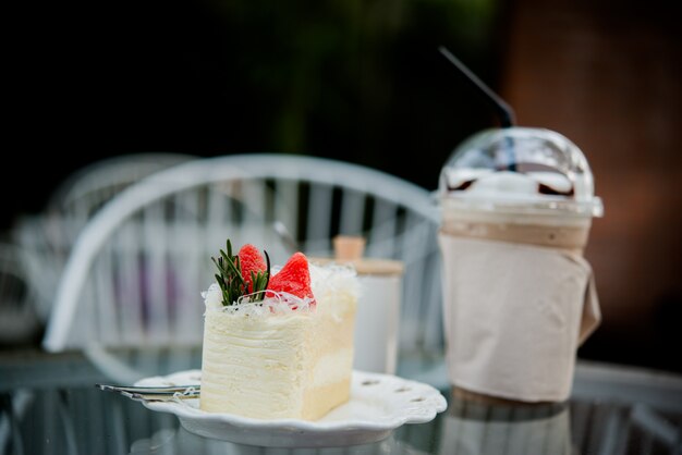 Cake with ice coffee on table in coffee shop