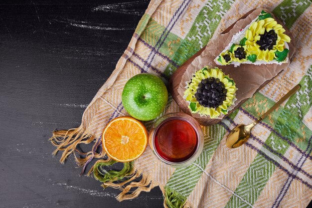 Cake with sunflower style decoration in a wooden platter with wine.