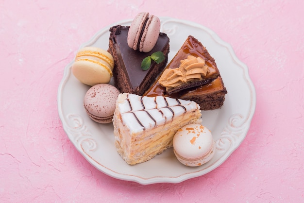 Free photo cakes and macarons on plate with mint