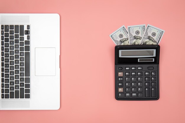 Calculator laptop and dollar bills on colored background flat lay