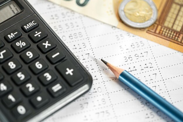 Калькулятор денег и карандаш крупным планом на размытом фоне